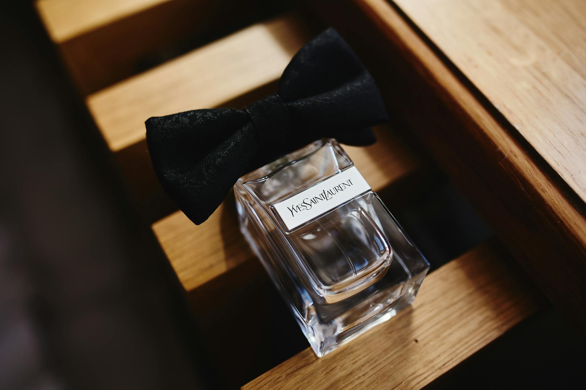 Stylish glass perfume bottle adorned with a black bow, offering a touch of luxury and elegance.